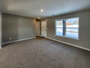 Bright and airy living room with cozy carpet and natural light streaming in.