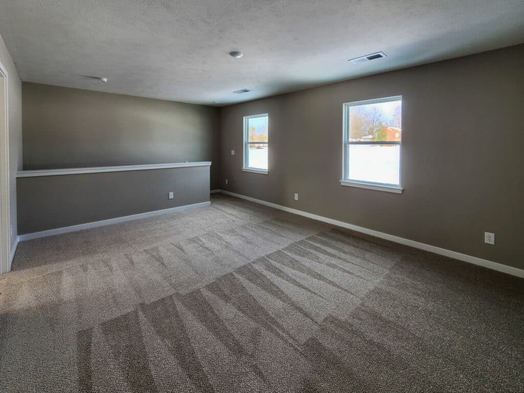 Spacious living room filled with natural light and cozy carpet for comfort.