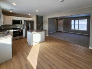 Modern open-concept kitchen and living room design featuring natural light and stylish finishes.