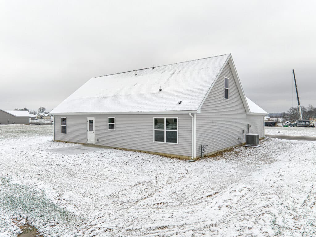 Modern home surrounded by snow on spacious grounds, perfect for a winter retreat.