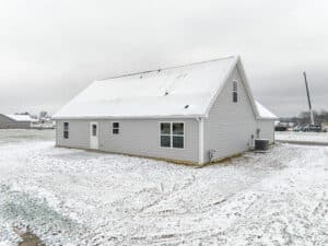 Modern home surrounded by snow on spacious grounds, perfect for a winter retreat.