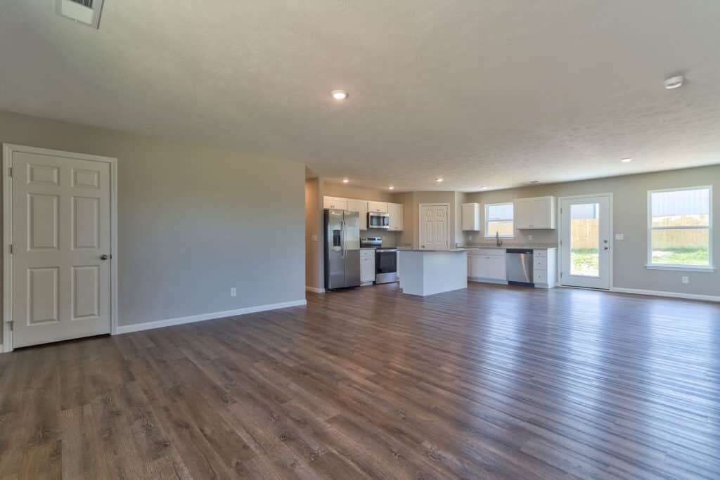 Spacious open-concept living room with modern kitchen and stylish flooring.