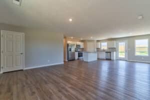 Spacious open-concept living room with modern kitchen and stylish flooring.