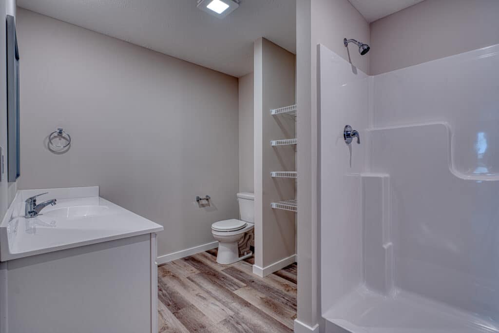 Modern bathroom design featuring a sleek shower, toilet, and stylish cabinetry.