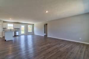 Modern spacious living room with hardwood floors and natural light throughout.