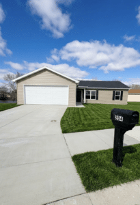 Charming waterfront home with a lush lawn and inviting driveway.