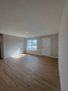 Spacious waterfront living room with abundant natural light and hardwood floors.