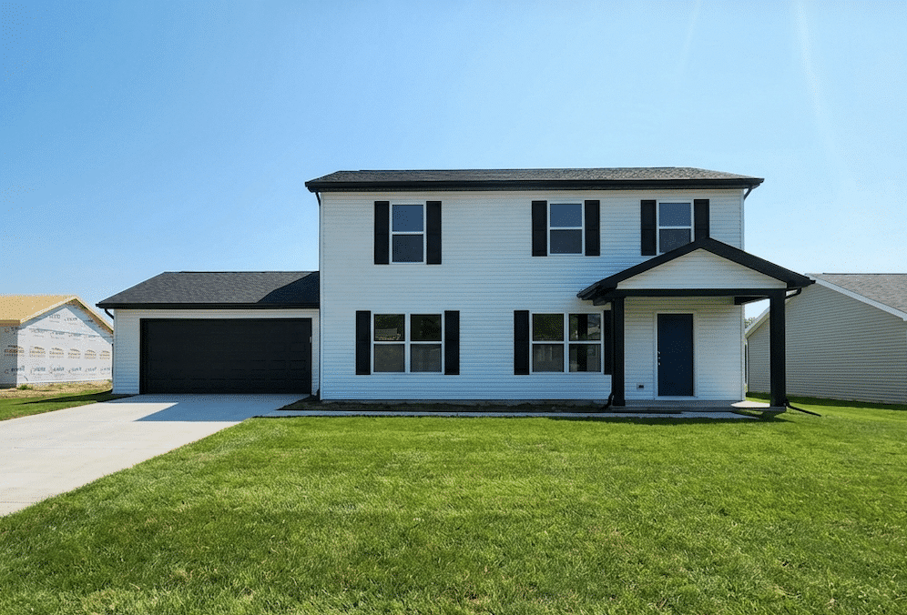 Charming two-story home with lush lawn and a welcoming front porch.