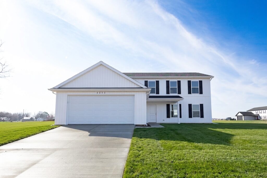 Modern white house at 4633 Sassafras Court with green lawn and clear blue sky backdrop.