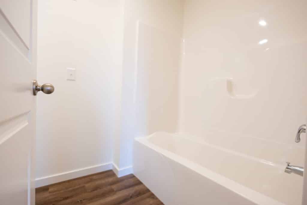 Clean bathroom corner featuring a bathtub and modern fixtures in a bright space.