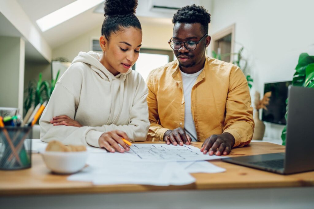 Couple collaborating on home design plans at a modern workspace.