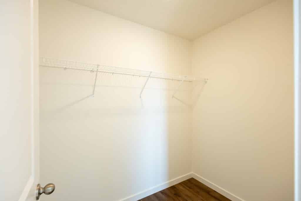 Spacious empty closet with white shelving for organized storage solutions.