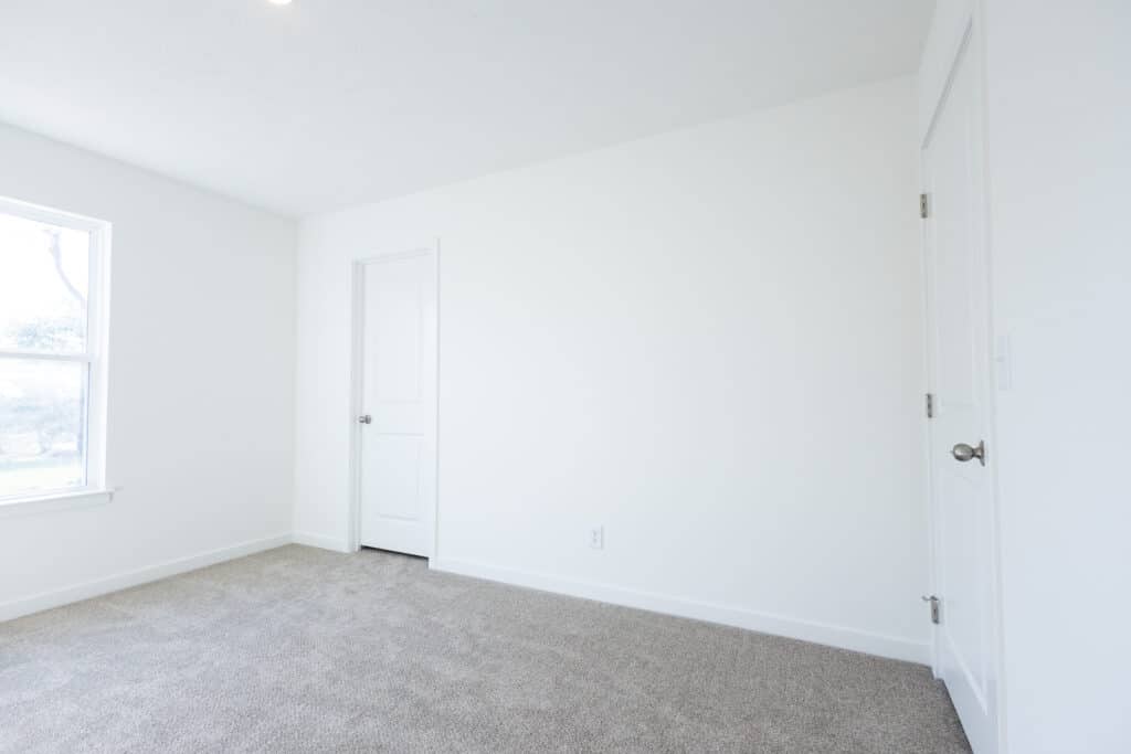 Bright, empty room with soft carpet and neutral walls ready for staging or decoration.