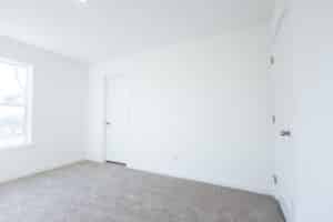 Bright, empty room with soft carpet and neutral walls ready for staging or decoration.