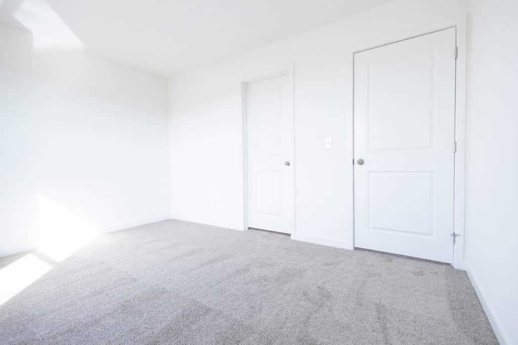 Bright, empty room with white walls and soft carpet, perfect for new decorating ideas.