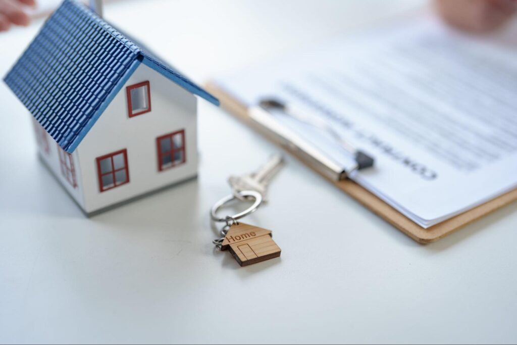 Model home with keys and paperwork illustrating the journey to homeownership.