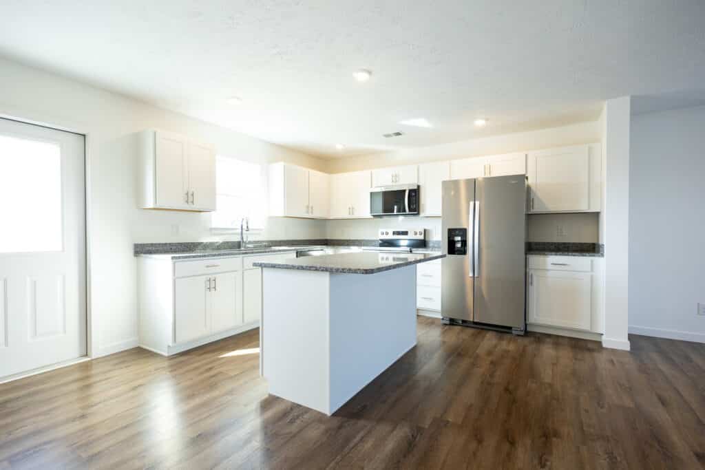 Modern kitchen interior with stainless steel appliances and stylish white cabinetry.