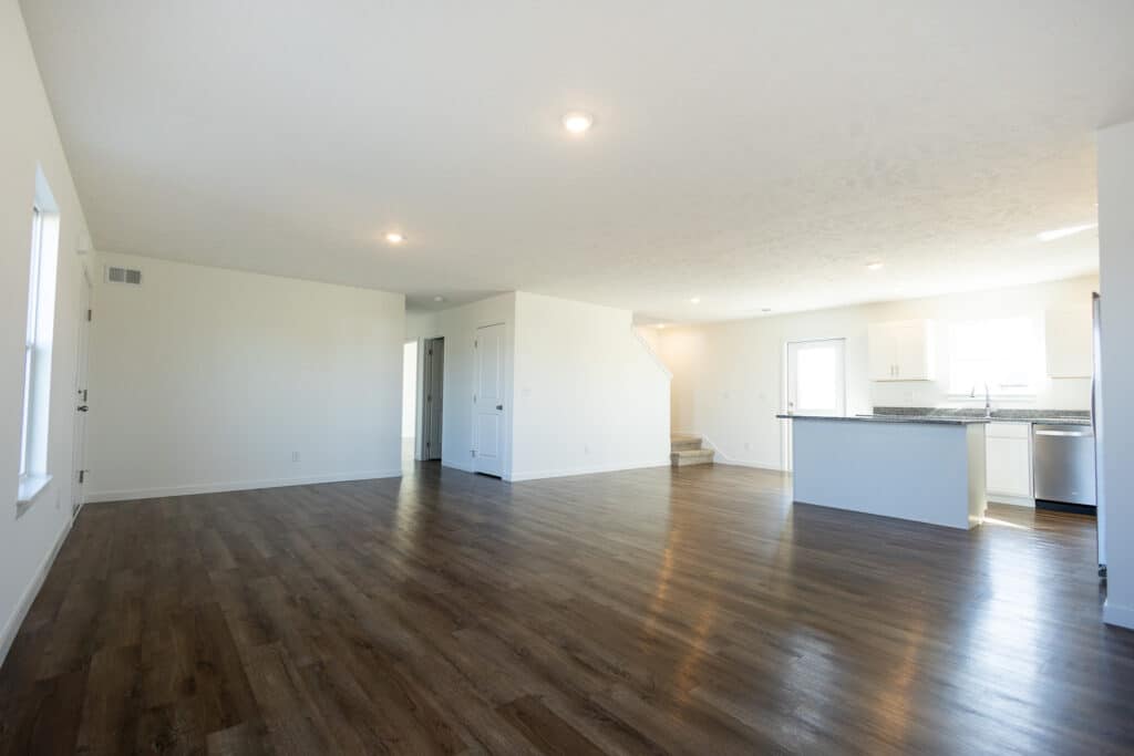 Spacious modern living room with light wood flooring and a bright, open design.