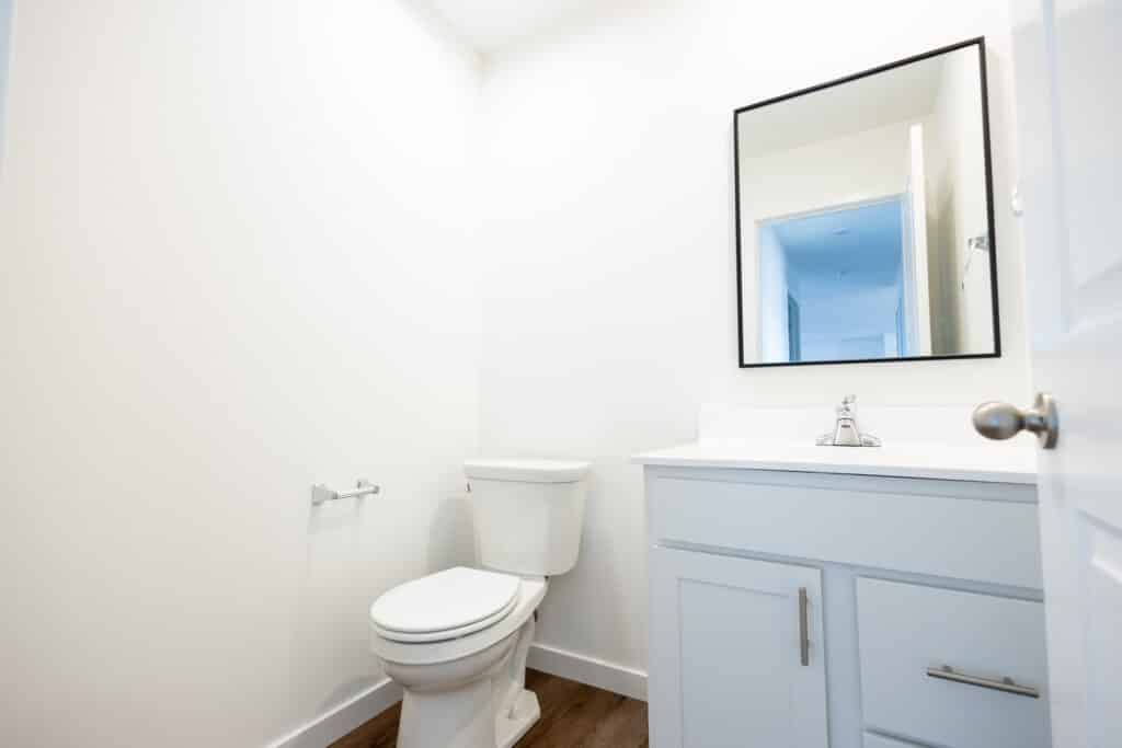 Spacious modern bathroom featuring a sleek toilet and minimalist cabinetry.