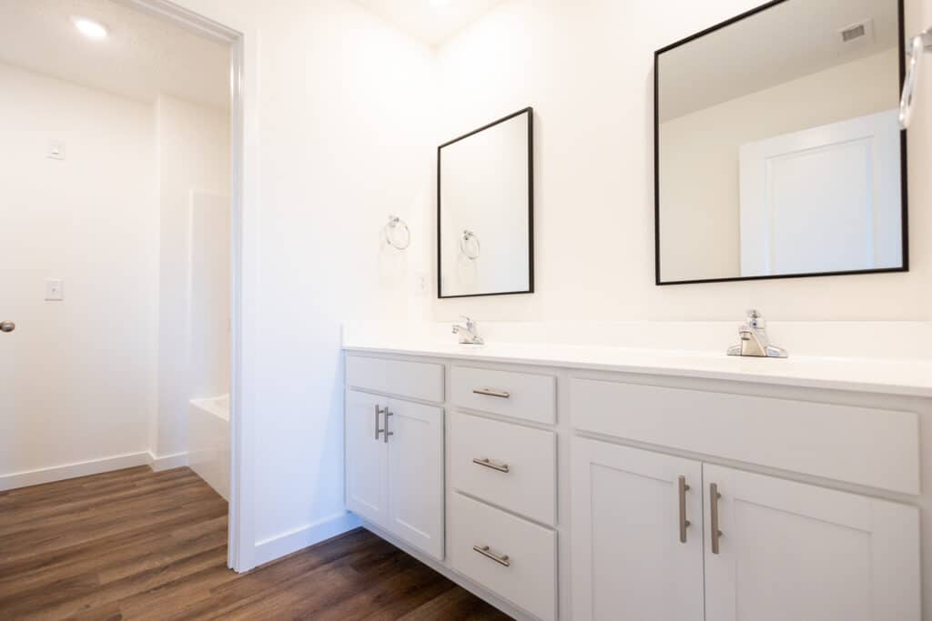 Modern bathroom design featuring dual sinks and stylish mirrors in a bright space.