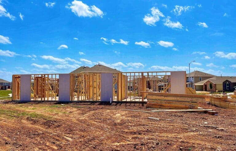 New home being built under a clear blue sky with wooden framing.