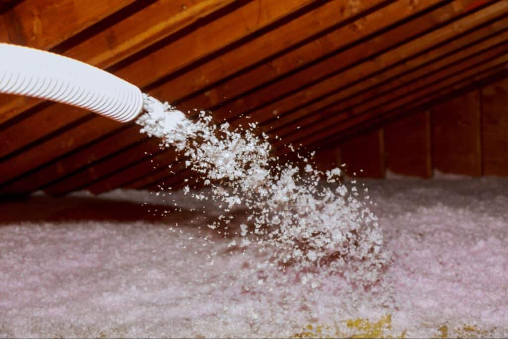 Cellulose insulation being applied in an attic for energy efficiency.