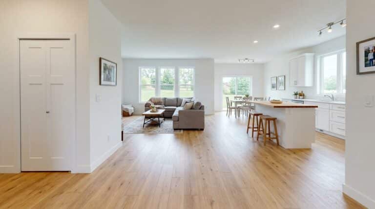 Bright and open modern living room featuring a stylish kitchen and natural light.