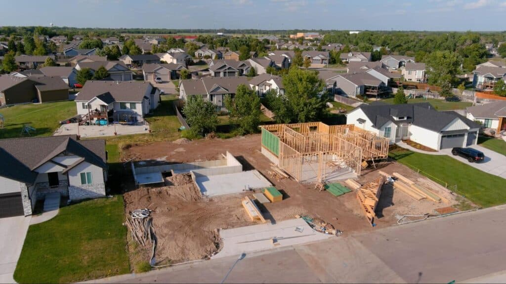 Residential construction site showing framing progress in a suburban neighborhood.