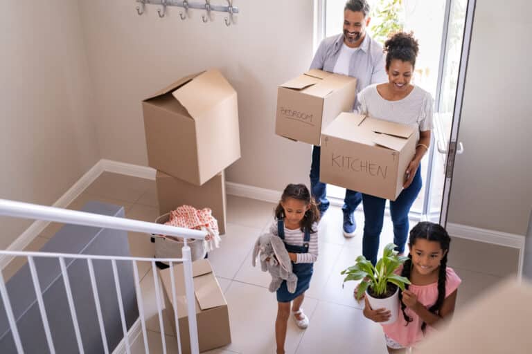 Happy multiethnic family unpacking boxes together in their new home on moving day.
