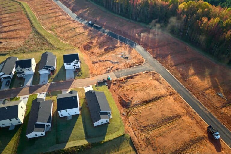 Aerial view of a new housing development under construction with cleared land.