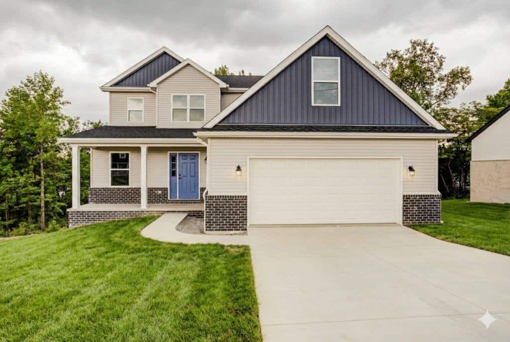 Modern home exterior with blue accents, green lawn, and a welcoming driveway.