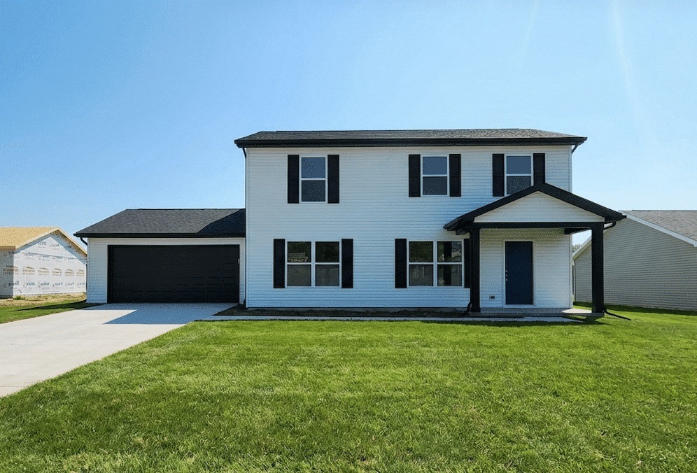 Modern two-story house with a garage and green lawn in a sunny neighborhood.